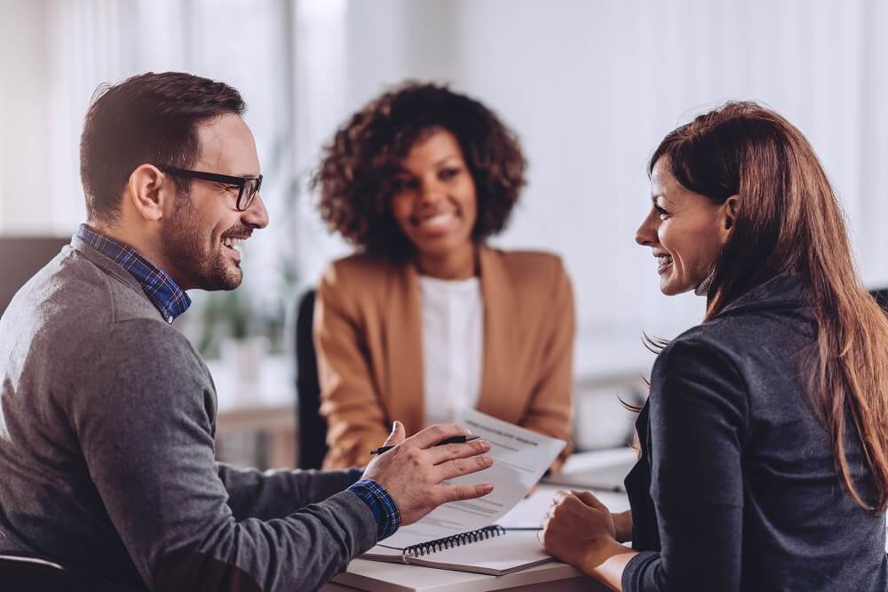 Three people having a meeting and smiling